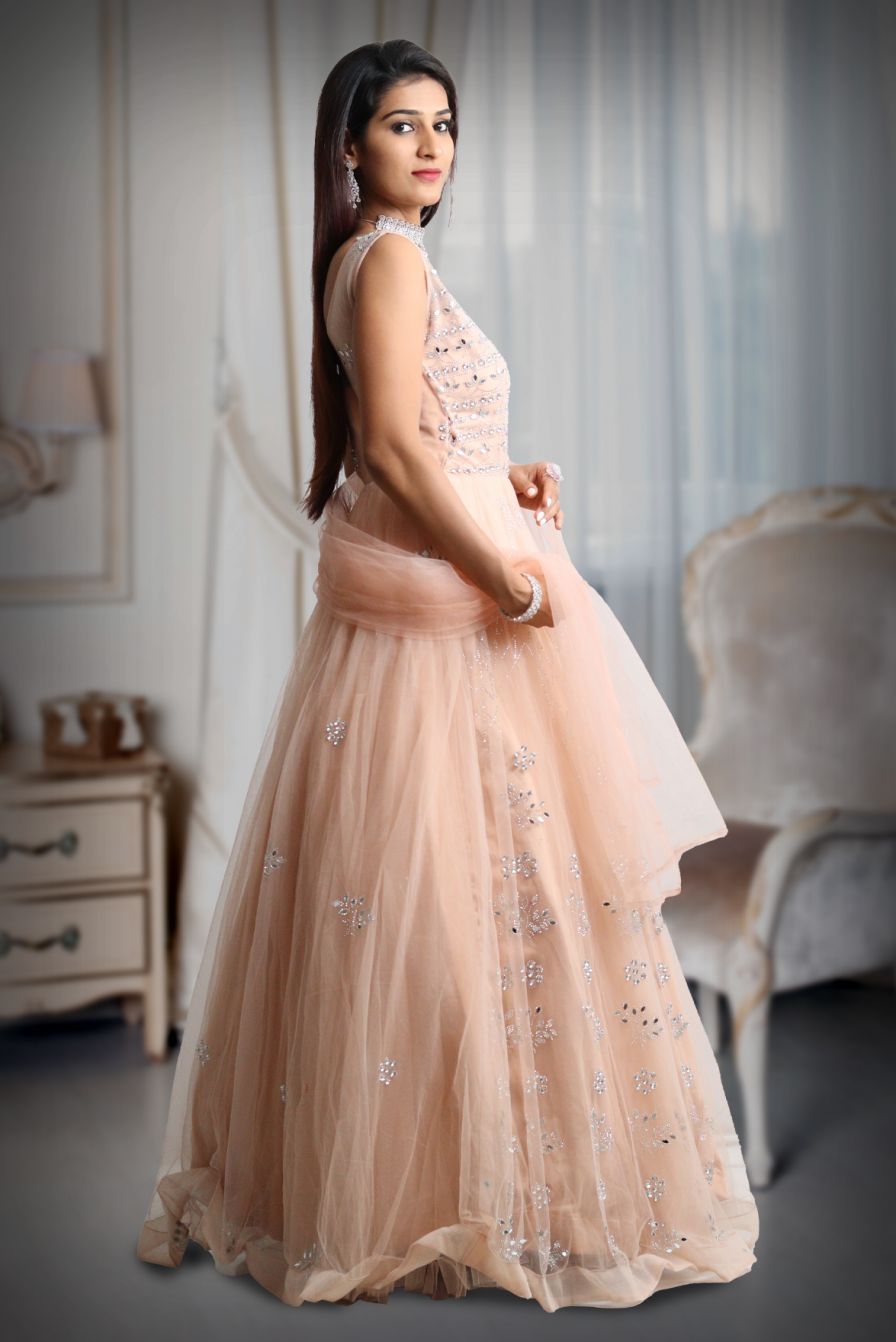 Pastel peach mirror work net gown with exquisite detailing on yoke