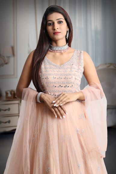 Pastel peach mirror work net gown with exquisite detailing on yoke